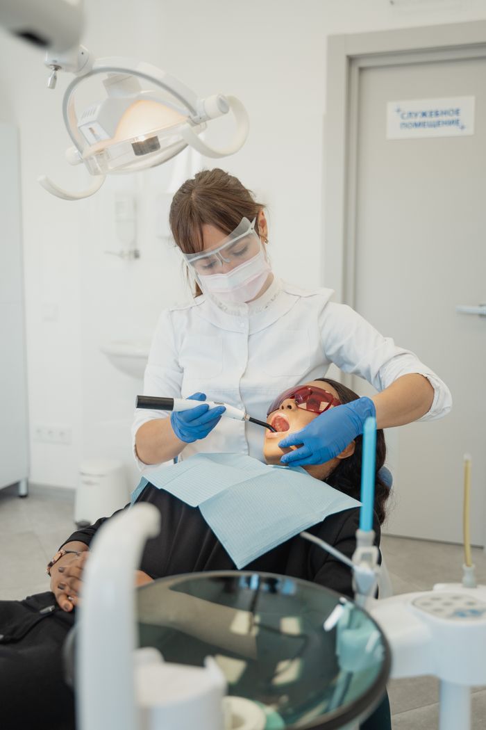 Dentist examining a patient using dental tools in a modern clinic.