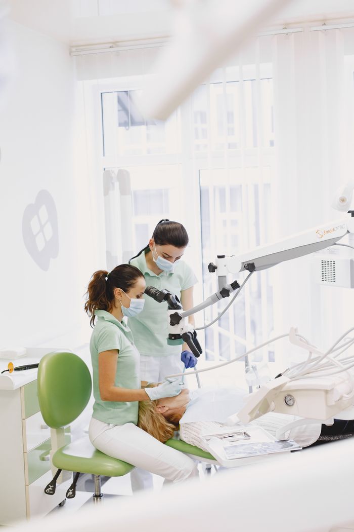 Dental professionals conducting a procedure in a bright, modern clinic.